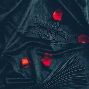 red rose petals on black leather background with lace mask; https://cdn.shopify.com/videos/c/o/v/e9534b8bd1cc40a093060a816740d17a.mp4