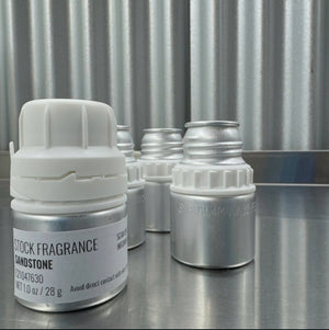 Set of small stock fragrance containers on a metallic surface with a corrugated metal background