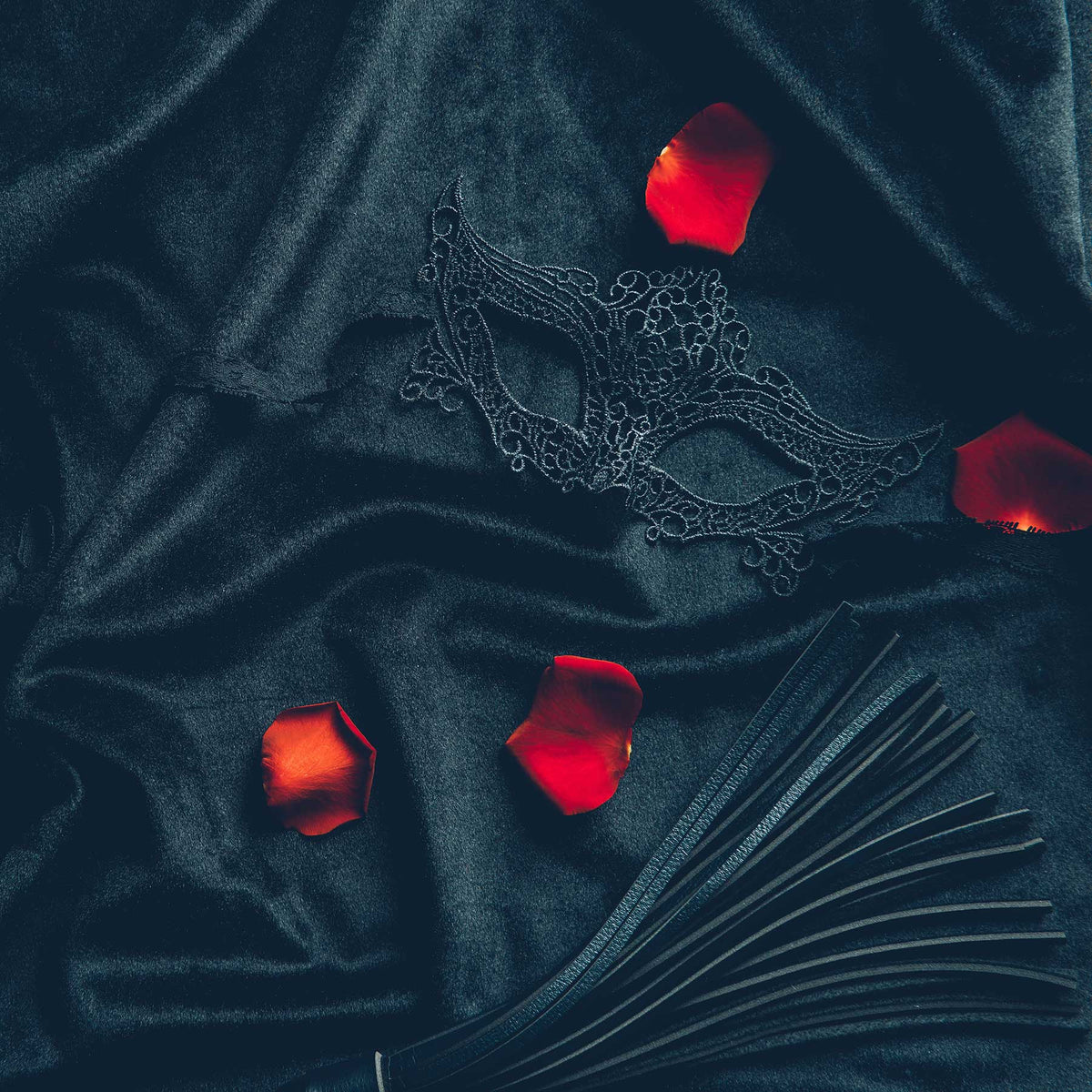red rose petals on black leather background with lace mask; https://cdn.shopify.com/videos/c/o/v/e9534b8bd1cc40a093060a816740d17a.mp4