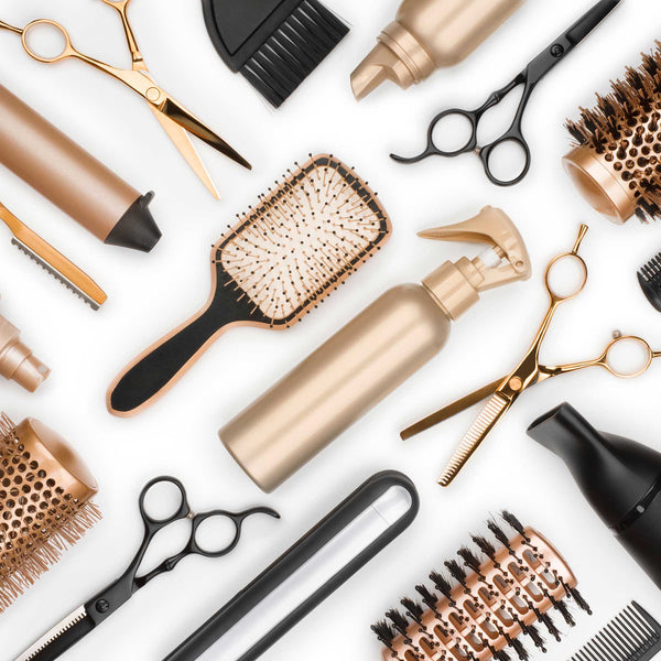 Collection of hair styling tools including scissors, hairbrushes, and blow dryers on a white background
