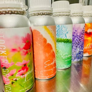 Row of colorful stock fragrance bottles with floral and fruit designs on labels