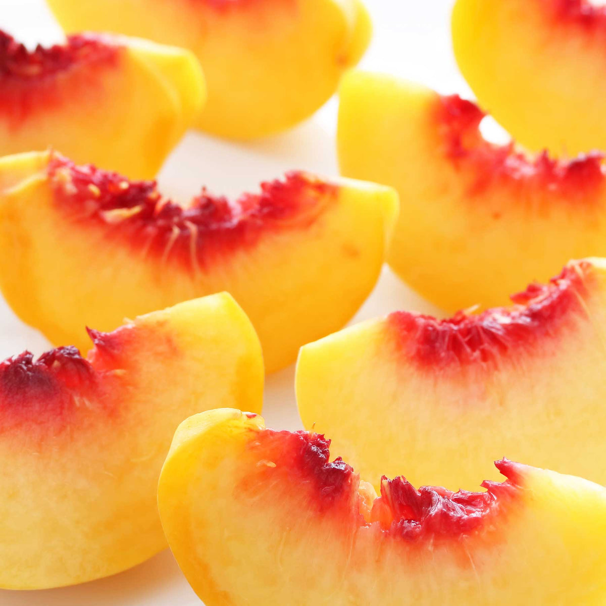 juicy yellow peach cut in half showing pit; https://cdn.shopify.com/s/files/1/0457/0333/1991/files/Wild_Peach.mp4?v=1648580841