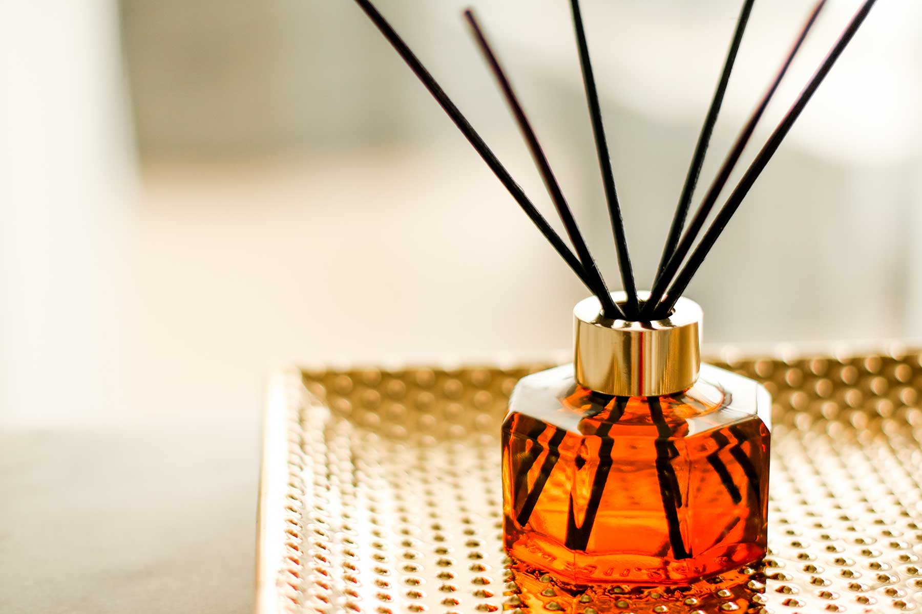 reed diffuser with red bottle and black reeds