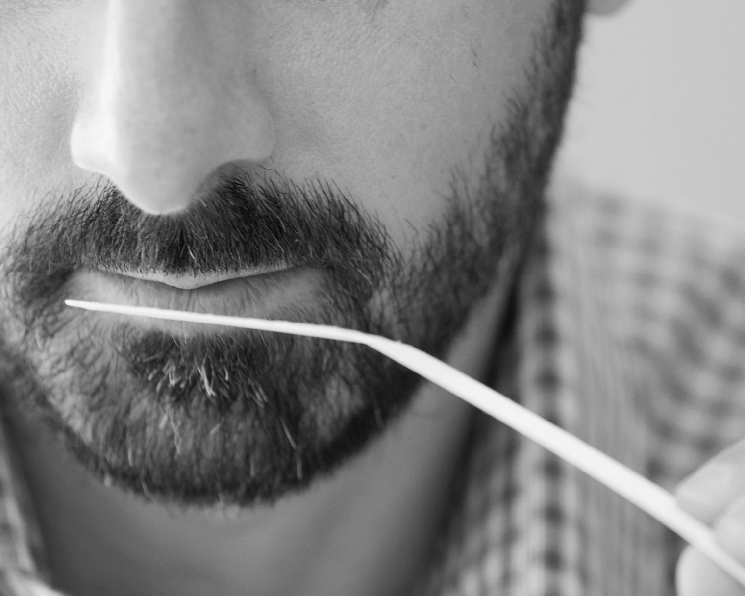 close up of bearded man smelling fragrance blotter